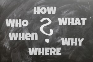 A chalkboard with the following words written on it: "How? What? Why? Where? When? Who?"