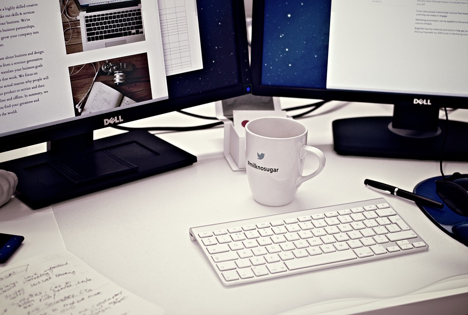 coffee cup on desk with computers