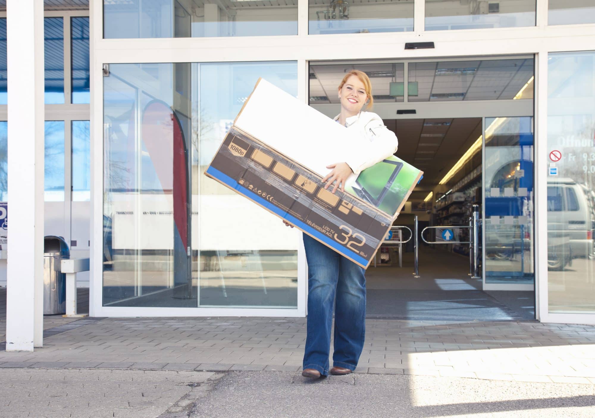 woman coming out of a store after purchase a television