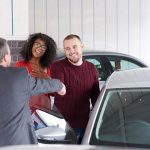 Couple shaking hands after buying a vehicle